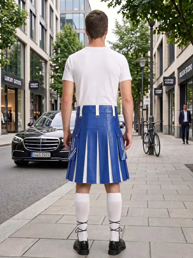 A man stands on a city sidewalk facing away from the camera, wearing a white T-shirt and a blue pleated kilt with white vertical stripes, white knee-high socks, and black shoes. Buildings, trees, a black car, and a bicycle are visible in the urban background.
