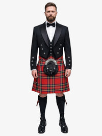 Man wearing a traditional Scottish royal stewart tartan kilt with a black prince charlie jacket and bow tie on a white background