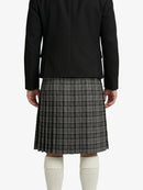 Person wearing a black jacket and plaid kilt on a white background
