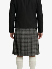 Person wearing a black jacket and plaid kilt on a white background
