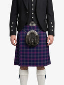 Person wearing a traditional Scottish kilt with a sporran on a white background