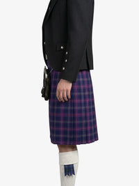 Person wearing a black jacket and purple plaid kilt on a white background