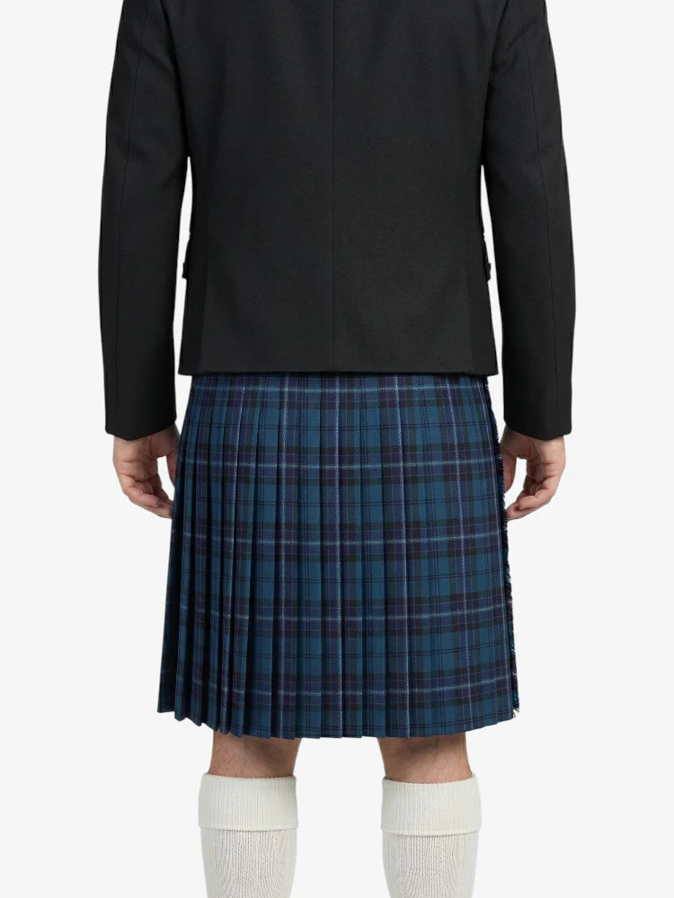Person wearing a black jacket and blue plaid kilt on a white background