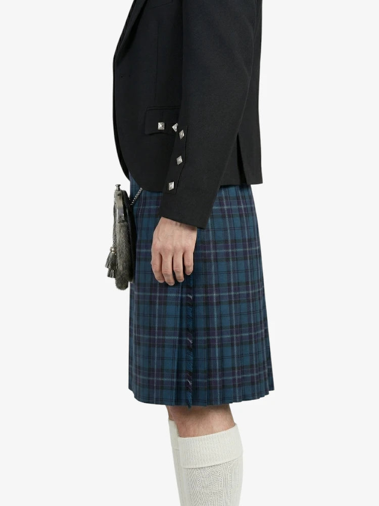 Person wearing a black blazer and blue plaid kilt on a white background