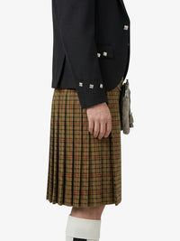 Person wearing a dark jacket and plaid kilt on a white background
