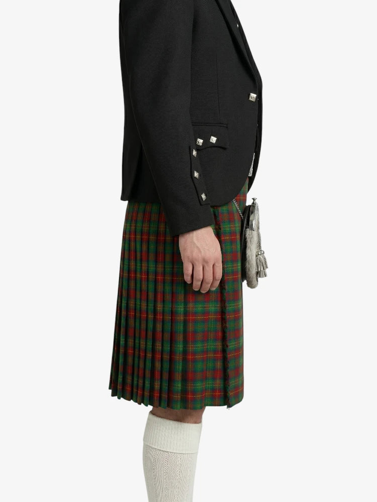 Person wearing a black blazer and green plaid kilt on a white background
