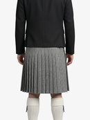 Person wearing a black coat and houndstooth pattern kilt on a white background