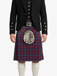 Person wearing a traditional Scottish kilt with a jacket on a white background