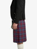 Person wearing a black jacket and red plaid kilt on a white background