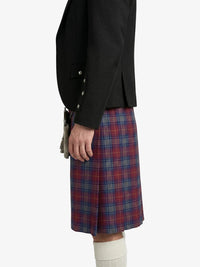 Person wearing a black jacket and red plaid kilt on a white background
