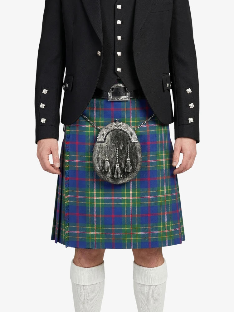 Person wearing a black jacket and a colorful plaid kilt on a white background