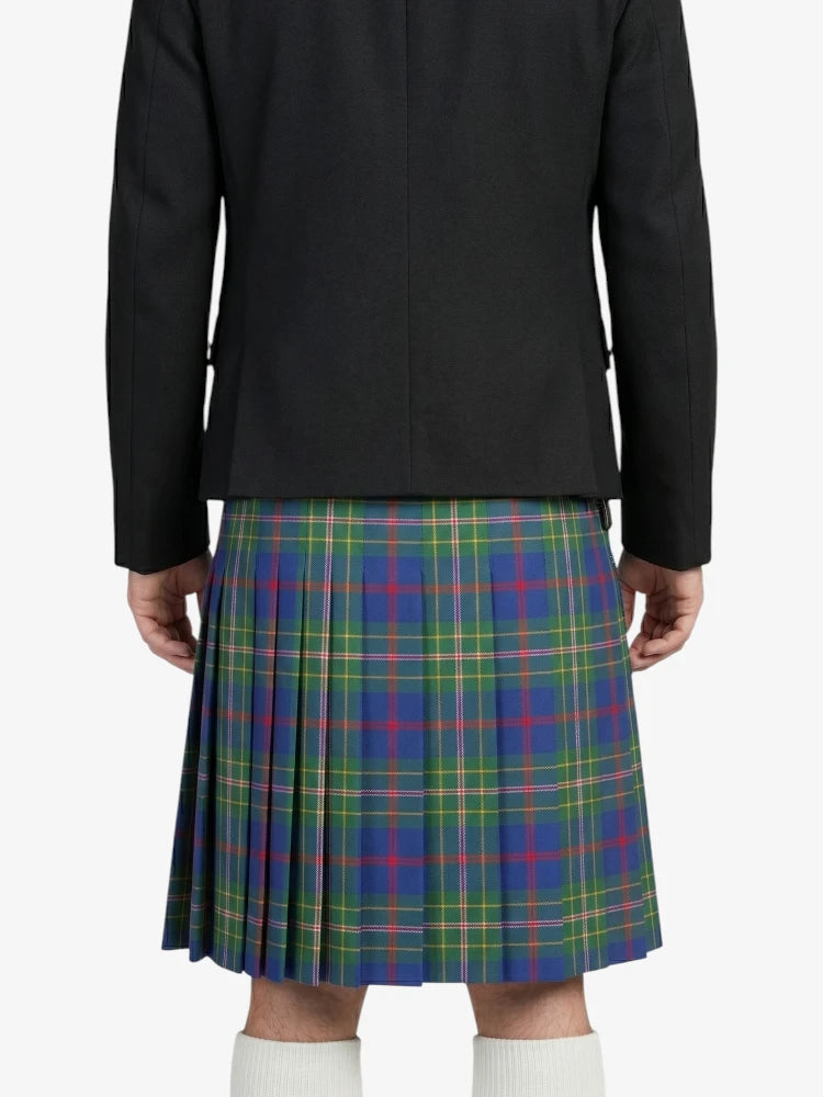 Person wearing a black jacket and a colorful plaid kilt on a white background