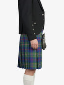 Person wearing a black jacket and plaid kilt on a white background