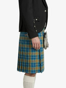 Person wearing a black jacket and blue plaid kilt on a white background