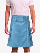 A person wearing a light blue faux-leather kilt with silver-tone metal hardware, side pockets, and a belt loop, paired with a pale pink t-shirt against a light gray background.