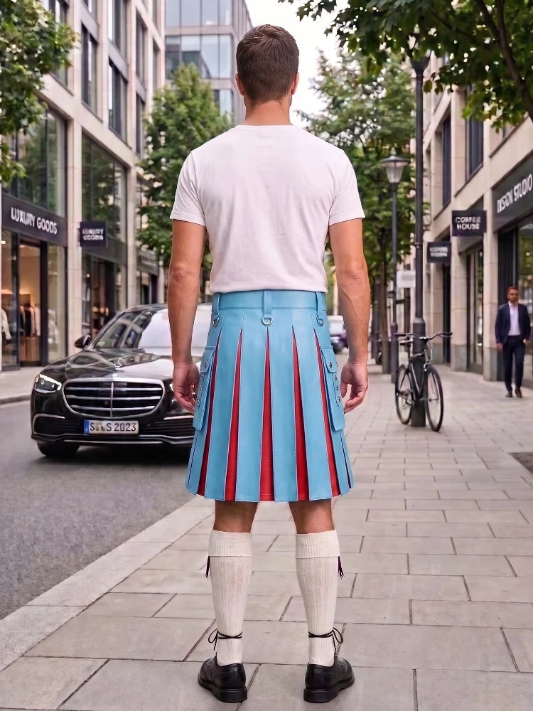 A man standing on a city sidewalk, viewed from behind, wearing a white t-shirt, a light blue pleated kilt with red vertical stripes, white knee-high socks, and black shoes. Buildings, trees, a black Mercedes car, and a bicycle are visible in the background.
