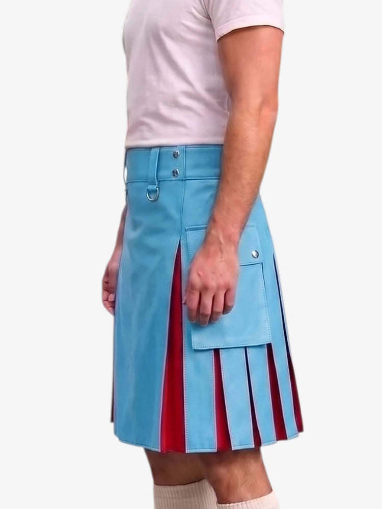 A man wearing a light blue kilt with red pleated side panels, a front flap pocket, and silver hardware, paired with a light pink t-shirt and beige socks, against a plain white background.