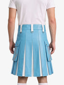 A model shown from the back wearing a light blue pleated faux-leather kilt with white accents, including belt loops, side zipper details, and vertical pleats, paired with a white t-shirt.