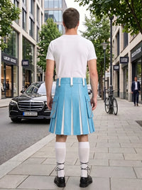 A man stands on a city sidewalk facing away from the camera, wearing a white T-shirt and a bright light blue pleated kilt with white vertical stripe details, white knee-high socks, and black shoes. Buildings, trees, a black Mercedes, and a bicycle are visible in the background.