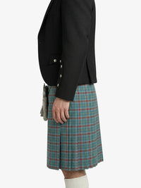 Person wearing a black blazer and plaid Kilt on a white background