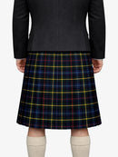 Person wearing a dark gray jacket and a blue plaid kilt on a white background