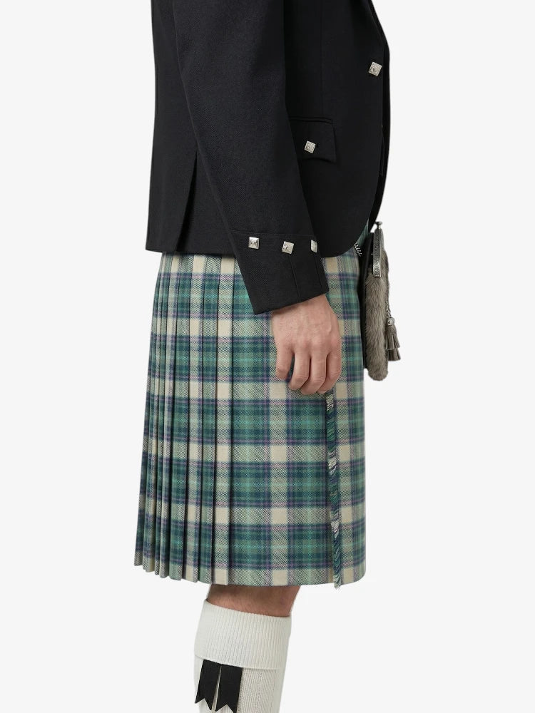 Person wearing a black jacket and plaid kilt on a white background