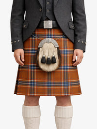 Person wearing a traditional Scottish kilt with a tartan pattern on a white background