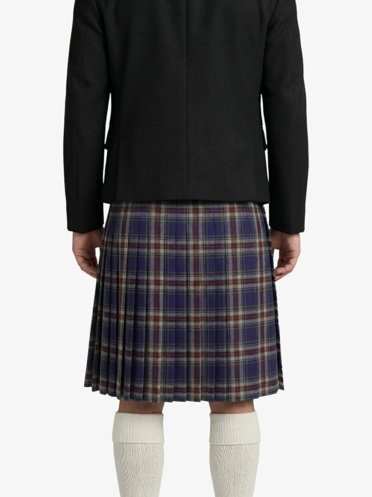 Person wearing a black jacket and plaid kilt on a white background