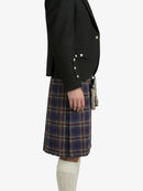 Person wearing a black blazer and plaid kilt on a white background