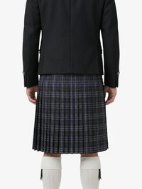 Person wearing a black jacket and plaid kilt on a white background