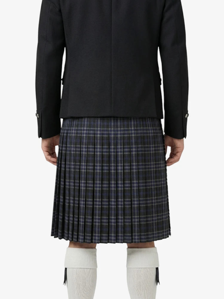 Person wearing a black jacket and plaid kilt on a white background