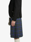 Person wearing a black blazer and a green and purple plaid kilt on a white background