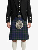 Person wearing a traditional Scottish kilt with a dark jacket on a white background