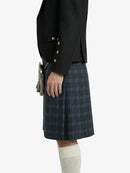 Person wearing a black blazer and plaid kilt on a white background