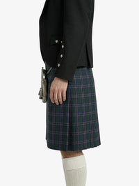 Person wearing a black blazer and plaid kilt on a white background