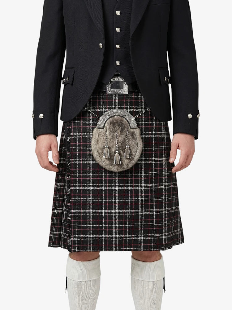 Person wearing a traditional Scottish kilt with a jacket on a white background