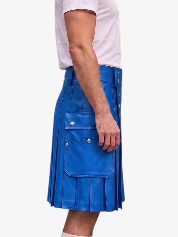 A person wearing a bright blue pleated leather kilt with flap pockets and silver-tone hardware, paired with a light pink t-shirt, shown from the side against a plain white background.