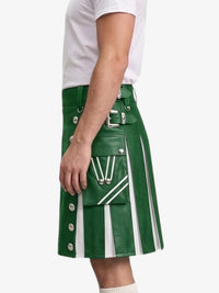 A green faux-leather kilt with white vertical pleats, silver buckle details, and white stripe accents, shown on a model wearing a white t-shirt against a light gray background.
