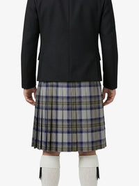 Person wearing a black jacket and plaid kilt on a white background