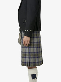 Person wearing a black jacket and plaid kilt on a white background