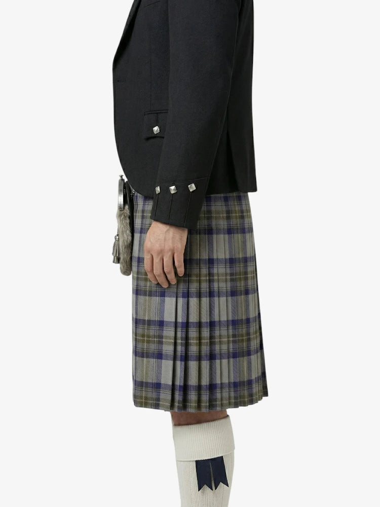 Person wearing a black jacket and plaid kilt on a white background