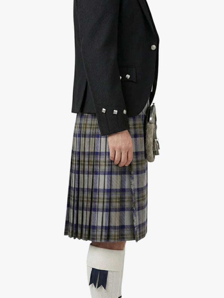 Person wearing a black jacket and plaid kilt on a white background
