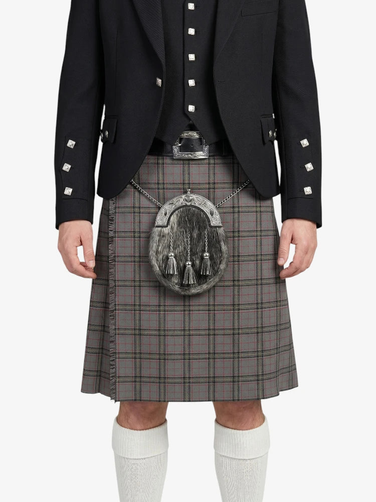 Person wearing a black jacket with decorative buttons and a gray plaid kilt on a white background