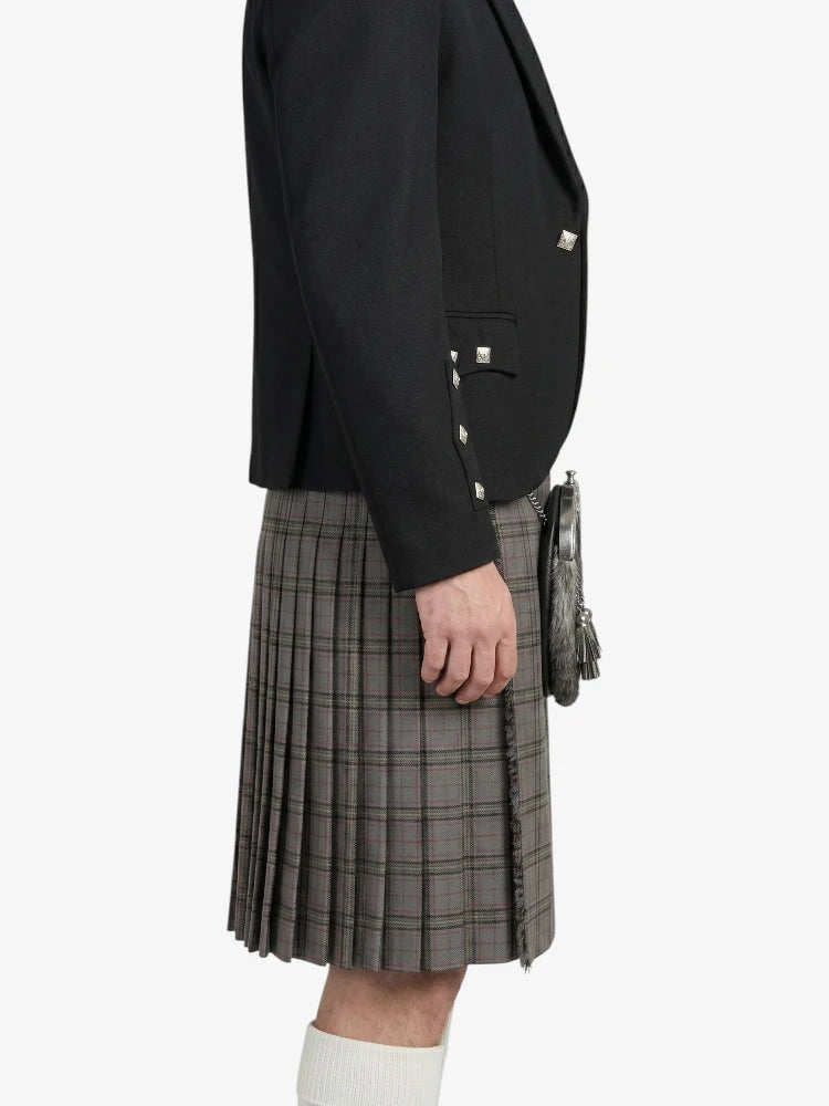 Person wearing a black jacket and gray plaid kilt on a white background