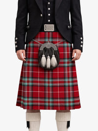 Person wearing a red tartan kilt with a black jacket on a white background