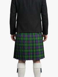 Person wearing a black jacket and green plaid kilt on a white background
