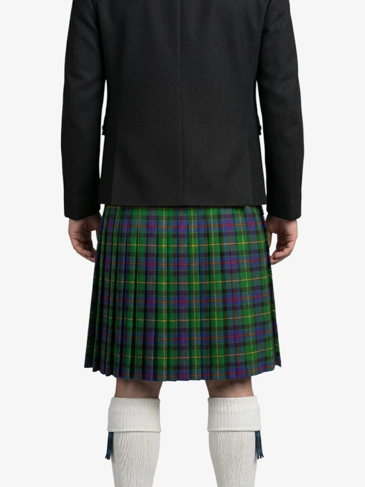 Person wearing a black jacket and green plaid kilt on a white background