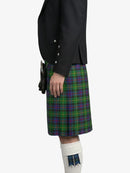 Person wearing a black jacket and green plaid kilt on a white background