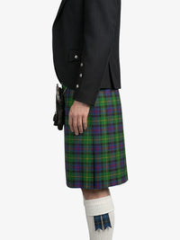 Person wearing a black jacket and green plaid kilt on a white background
