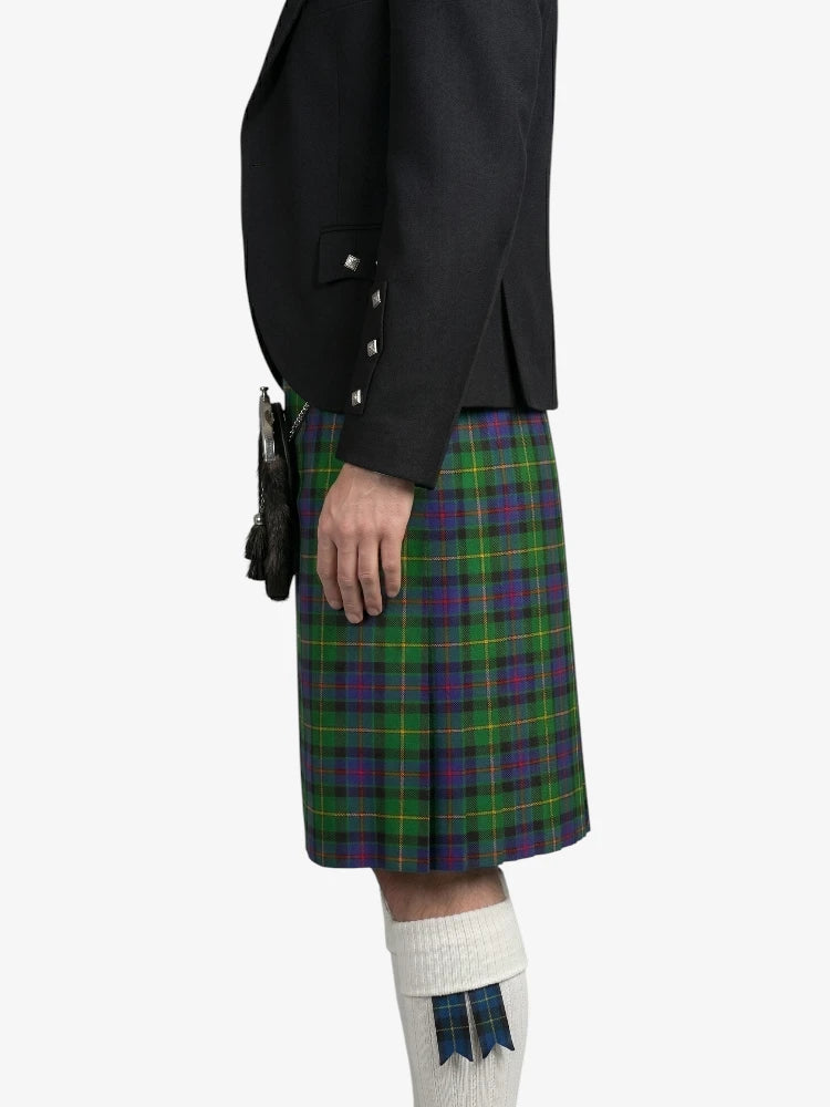 Person wearing a black jacket and green plaid kilt on a white background
